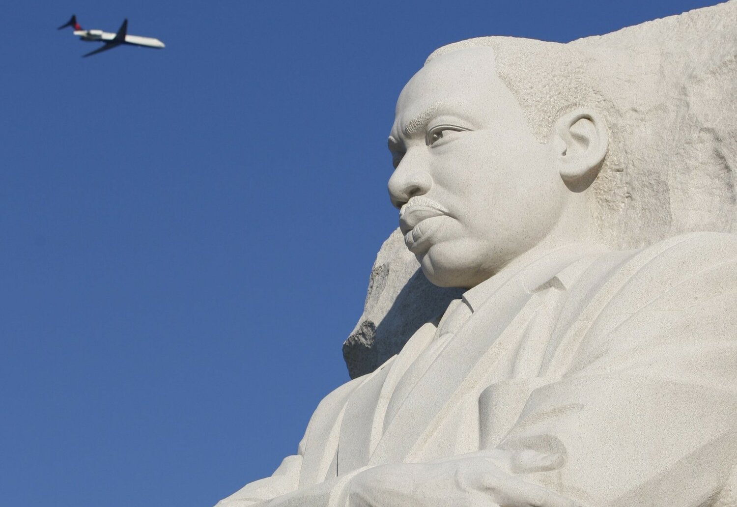 A plane flies over a 30-foot sculpture of Dr. Martin Luther King Jr. on the National Mall in Washington Aug. 22, 2011, the year it opened. As the nation celebrates the legacy of Dr. Martin Luther King Jr. on Jan. 15, 2024, both personal conversion and action are needed to build what the slain civil rights leader called “the beloved community,” say Catholic clergy and lay leaders.